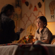 Young Maya sitting on her bed using ASL with her dad.